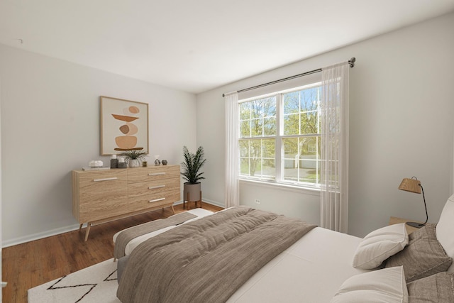 bedroom with wood finished floors and baseboards