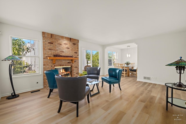 living area with plenty of natural light, light wood-style floors, and baseboards