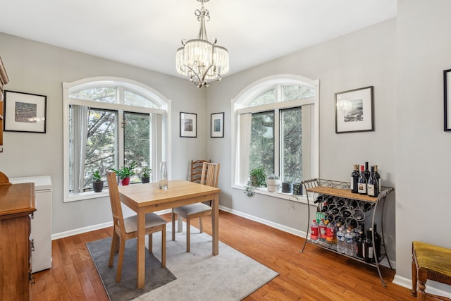 5155 Madison St Unit 204, Skokie, IL 60077 - dining area featuring a chandelier, light wood-type flooring, and baseboards