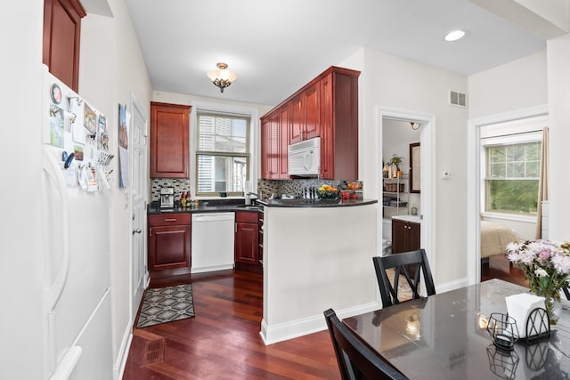 3848 N Lamon Ave Unit 1, Chicago, IL 60641 - kitchen featuring white appliances, dark brown cabinets, dark wood-style flooring, dark countertops, and recessed lighting