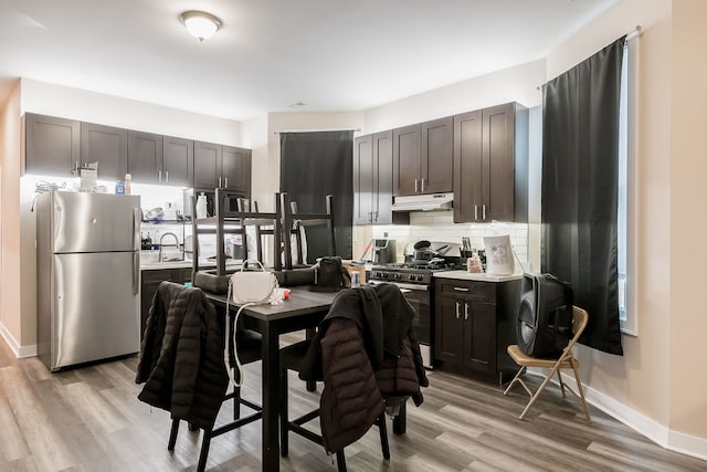 9841 S Ewing Ave, Chicago, IL 60617 - kitchen featuring stainless steel appliances, under cabinet range hood, backsplash, light wood-style floors, and light countertops