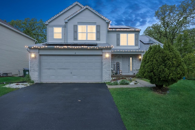 4 W Tall Oak Dr, Hainesville, IL 60073 - traditional-style home featuring asphalt driveway, an attached garage, brick siding, and solar panels