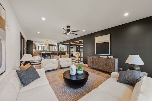 living room with light wood-style flooring, a ceiling fan, and recessed lighting
