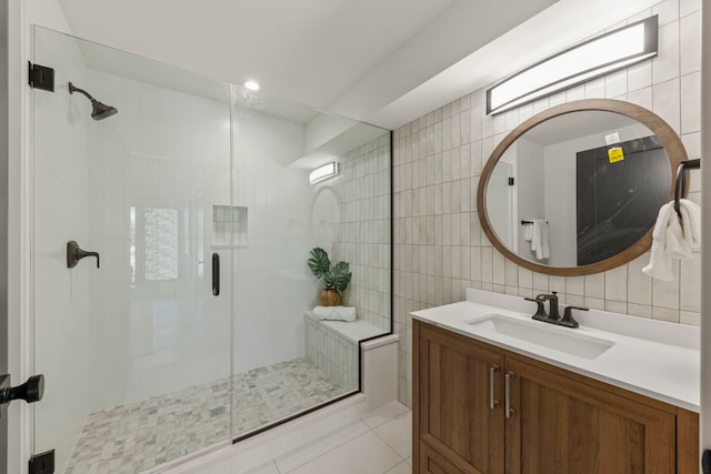 full bath featuring tile walls, a shower stall, vanity, and backsplash