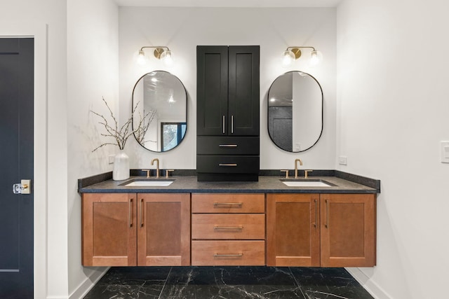 full bath with marble look tile flooring, baseboards, and double vanity