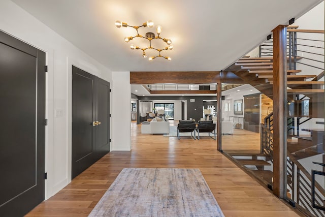entryway with stairway, a chandelier, and wood finished floors