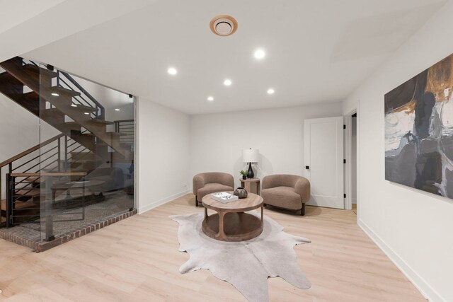 sitting room featuring wood finished floors, recessed lighting, stairway, and baseboards
