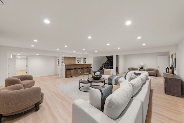 living room with stairway, recessed lighting, light wood finished floors, bar, and baseboards