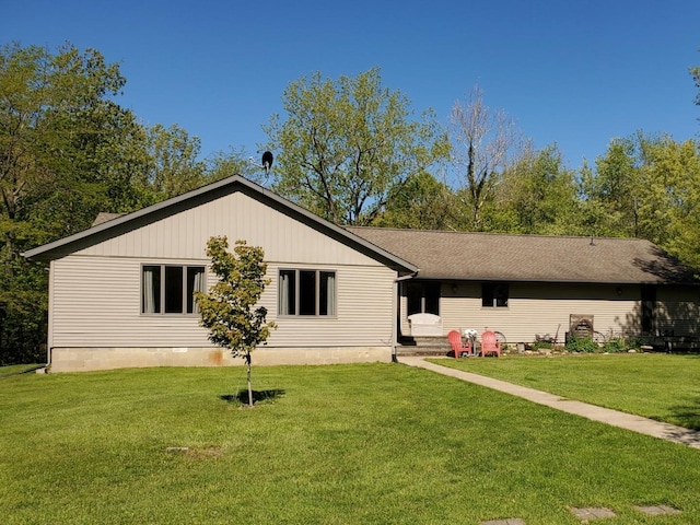 rear view of property with a yard and a shingled roof