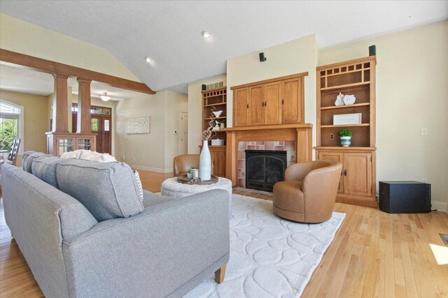 2297 Deer Ridge Ct, Carlock, IL 61725 - living area featuring a tiled fireplace, light wood finished floors, vaulted ceiling, baseboards, and recessed lighting