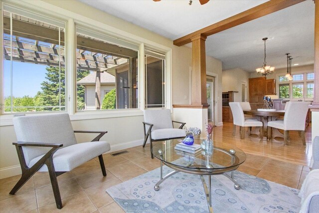2297 Deer Ridge Ct, Carlock, IL 61725 - living room featuring light tile patterned floors, baseboards, a chandelier, and ornate columns