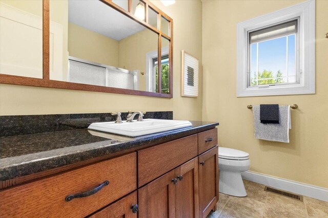 2297 Deer Ridge Ct, Carlock, IL 61725 - bathroom with baseboards, vanity, toilet, tile patterned flooring, and an enclosed shower