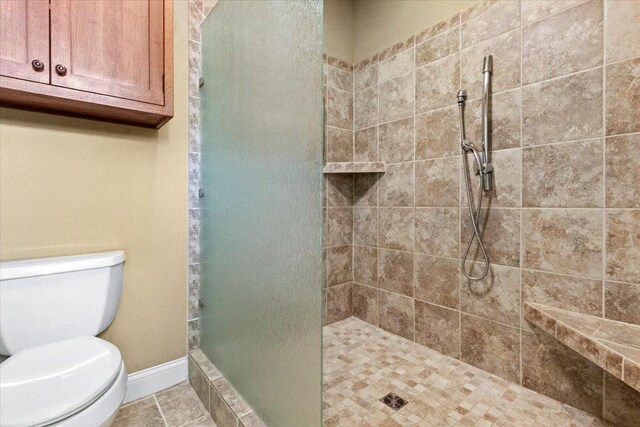 2297 Deer Ridge Ct, Carlock, IL 61725 - bathroom with a tile shower, toilet, and baseboards