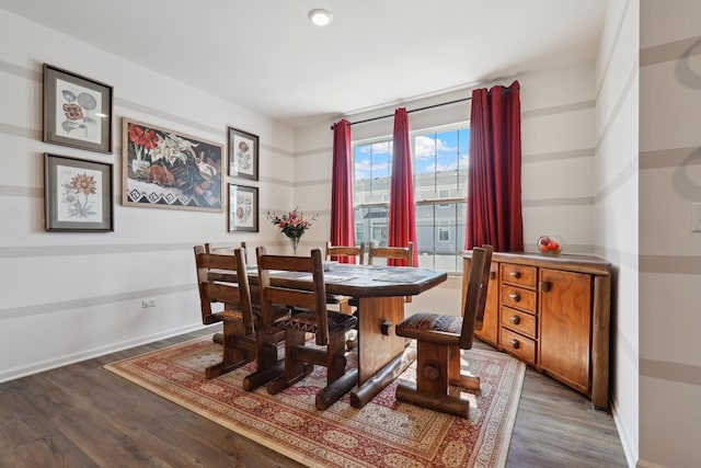 dining space featuring wood finished floors and baseboards