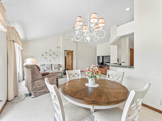 dining area featuring light colored carpet, a chandelier, vaulted ceiling, baseboards, and a ceiling fan