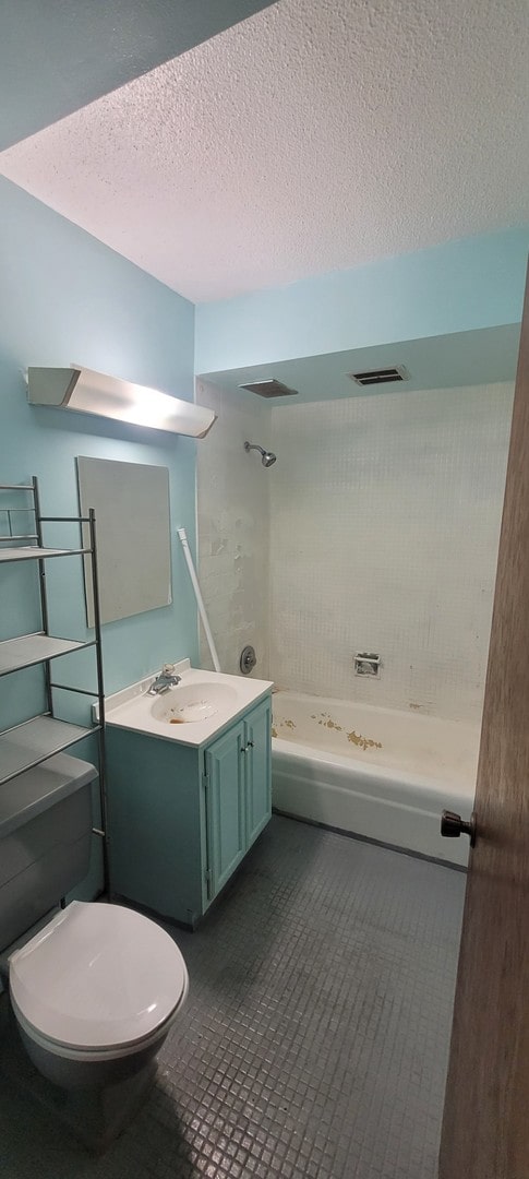 7234 W N Ave Unit 604, Elmwood Park, IL 60707 - bathroom featuring tub / shower combination, a textured ceiling, vanity, and toilet