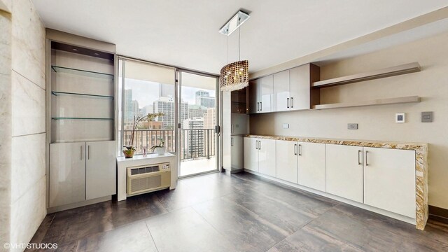 71 E Division St Unit 1801, Chicago, IL 60610 - kitchen with open shelves, light countertops, decorative light fixtures, a view of city, and white cabinets