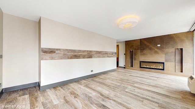 71 E Division St Unit 1801, Chicago, IL 60610 - unfurnished living room featuring wood finished floors, a tile fireplace, and baseboards