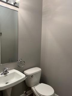 bathroom featuring a sink, toilet, and baseboards