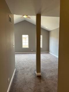 empty room featuring a ceiling fan, vaulted ceiling, carpet flooring, and baseboards