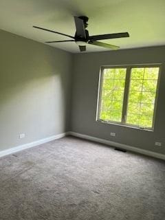 carpeted spare room with ceiling fan and baseboards