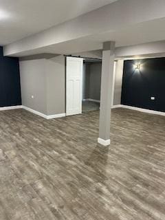 finished below grade area featuring baseboards and wood finished floors