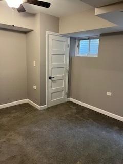spare room with dark carpet and baseboards