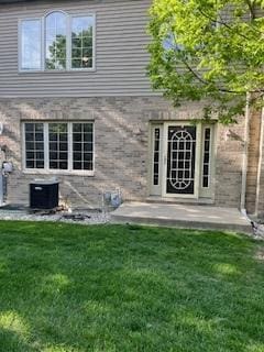 back of house featuring a lawn and central AC unit