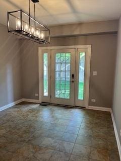 doorway with a chandelier and baseboards