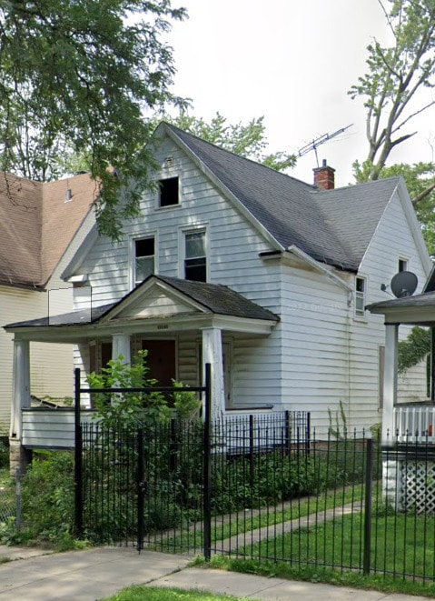 view of front of house featuring a fenced front yard, a chimney, and a shingled roof