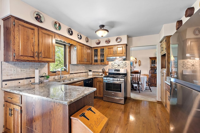 8120 Cherokee Trl, Tinley Park, IL 60477 - kitchen featuring stainless steel appliances, a sink, a peninsula, brown cabinets, and under cabinet range hood