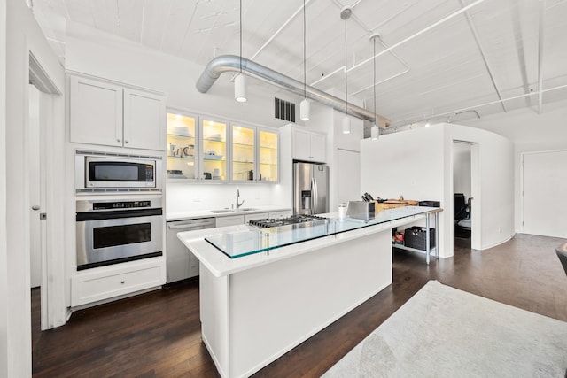 kitchen featuring appliances with stainless steel finishes, a sink, white cabinetry, and a kitchen island