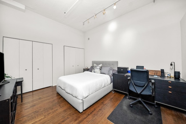 bedroom with two closets, wood finished floors, and a desk