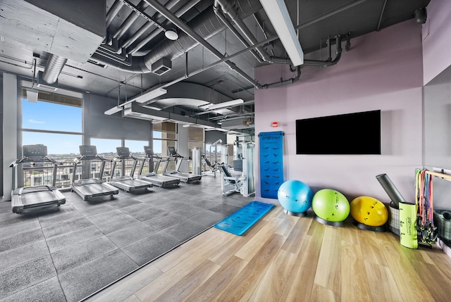 gym with wood finished floors and a wall of windows