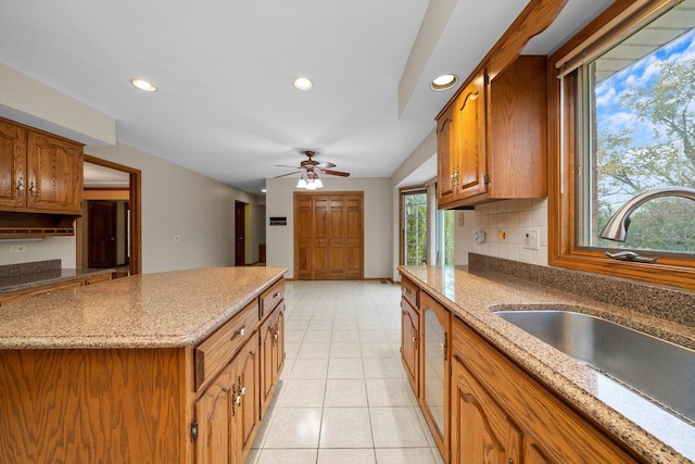 631 Indian Trail Dr, Palos Park, IL 60464 - kitchen with a sink, brown cabinetry, recessed lighting, ceiling fan, and light stone counters