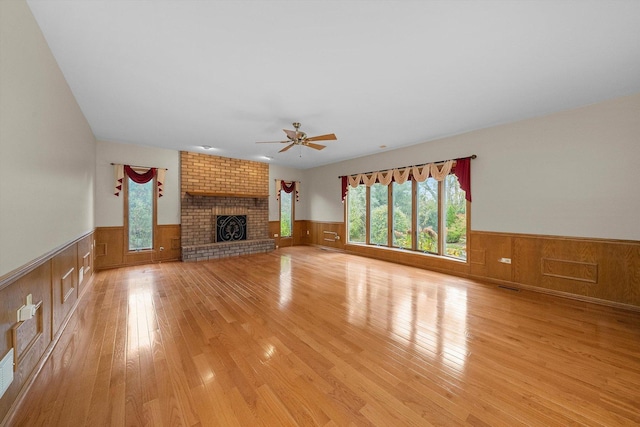 631 Indian Trail Dr, Palos Park, IL 60464 - unfurnished living room featuring a wainscoted wall, a ceiling fan, light wood-style floors, a fireplace, and wooden walls