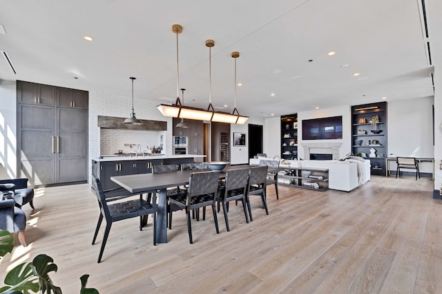 1109 W Washington Blvd Unit 5C, Chicago, IL 60607 - dining space featuring light wood-type flooring, recessed lighting, a fireplace, and built in shelves
