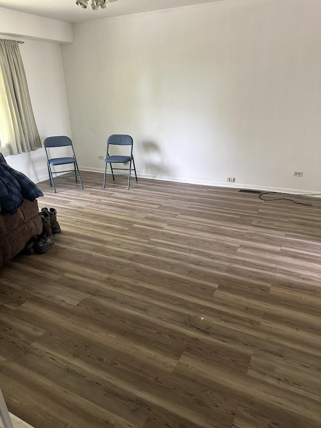 unfurnished bedroom with dark wood-type flooring and baseboards