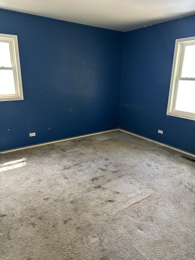 carpeted spare room featuring baseboards