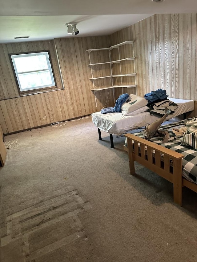 bedroom featuring wood walls and carpet flooring