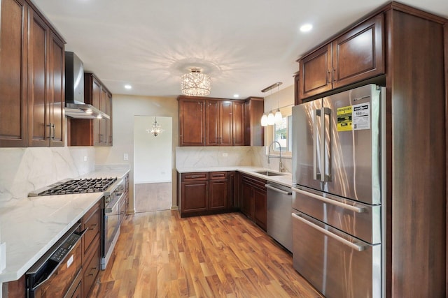 6709 W Menominee Pkwy, Palos Heights, IL 60463 - kitchen featuring stainless steel appliances, wall chimney range hood, a sink, light wood-style floors, and backsplash