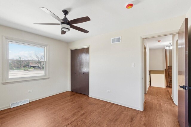 6709 W Menominee Pkwy, Palos Heights, IL 60463 - unfurnished bedroom with light wood-type flooring, a closet, baseboards, and ceiling fan