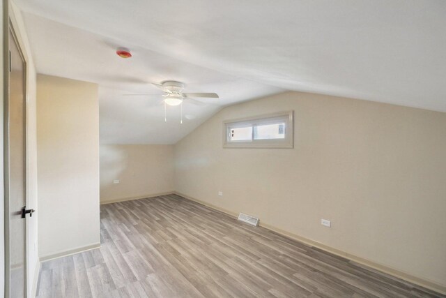 6709 W Menominee Pkwy, Palos Heights, IL 60463 - additional living space with light wood-style flooring, a ceiling fan, vaulted ceiling, and baseboards