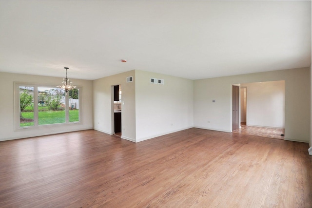 6709 W Menominee Pkwy, Palos Heights, IL 60463 - unfurnished living room with a chandelier, light wood-style floors, and baseboards