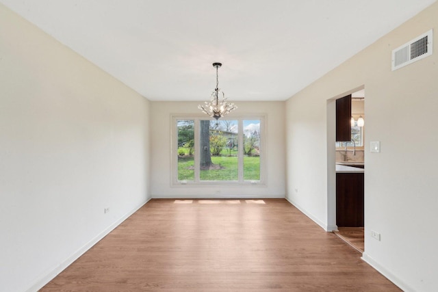 6709 W Menominee Pkwy, Palos Heights, IL 60463 - unfurnished dining area featuring a chandelier, light wood-type flooring, a sink, and baseboards