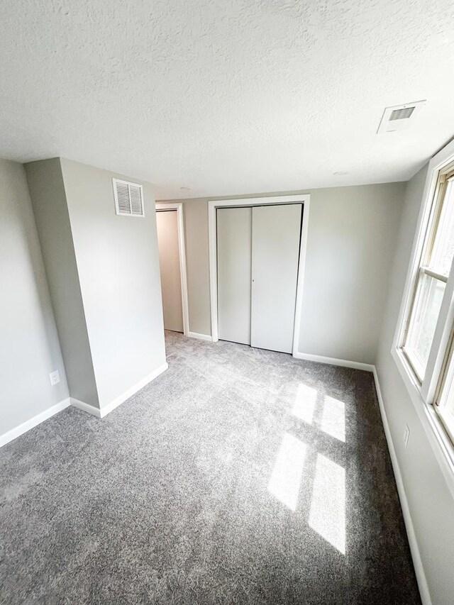 384 N Grand Ave, Bradley, IL 60915 - unfurnished bedroom with a textured ceiling, baseboards, carpet, and a closet