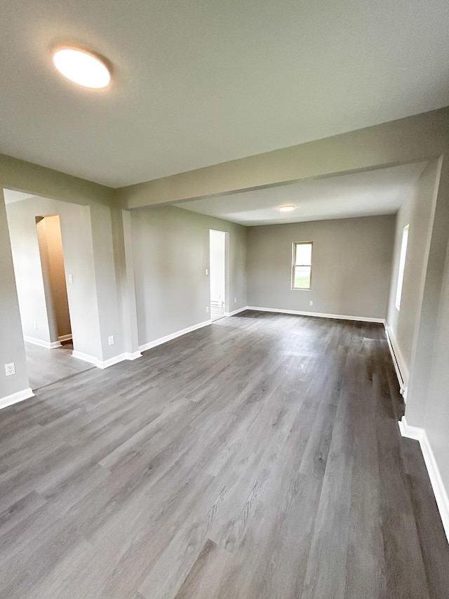 384 N Grand Ave, Bradley, IL 60915 - empty room featuring baseboards, dark wood-type flooring, and a baseboard heating unit