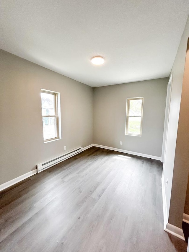 384 N Grand Ave, Bradley, IL 60915 - unfurnished room featuring a baseboard radiator, dark wood-style flooring, and baseboards