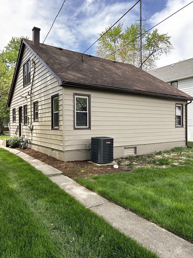 384 N Grand Ave, Bradley, IL 60915 - view of property exterior with a chimney, a yard, roof with shingles, and cooling unit