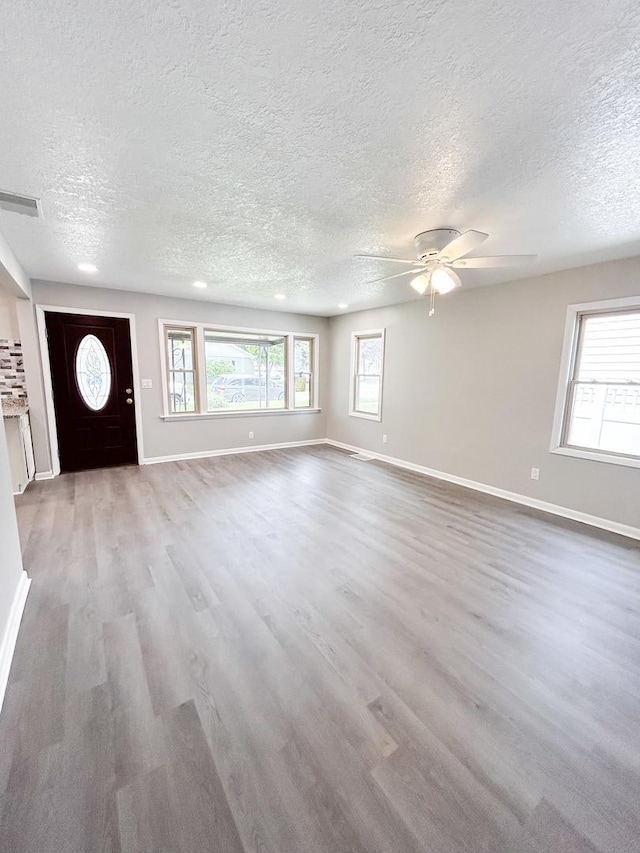 384 N Grand Ave, Bradley, IL 60915 - unfurnished living room featuring baseboards, wood finished floors, a textured ceiling, and a ceiling fan